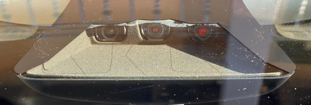 HW4 front camera cluster showing red-reflective lenses
