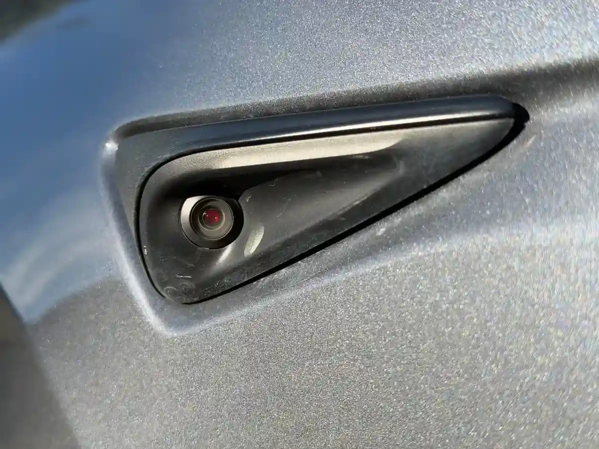 HW4 side repeater showing red-tinted lens and narrower turn signal LED